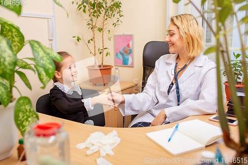 Image of Paediatrician doctor examining a child in comfortabe medical office