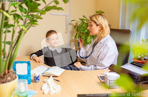 Image of Paediatrician doctor examining a child in comfortabe medical office