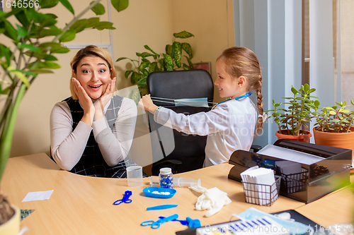 Image of Paediatrician doctor examining a child in comfortabe medical office. Little girl playing pretends like doctor for woman