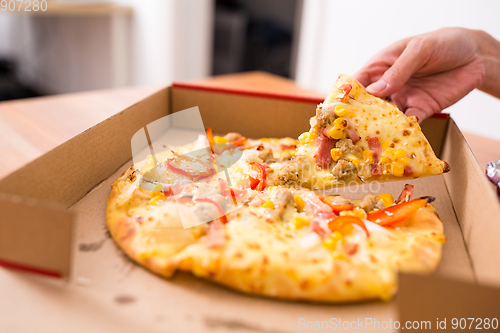 Image of Woman taking on slice from pizza