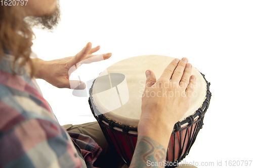 Image of Man plays ethnic drum darbuka percussion, close up musician isolated on white studio background