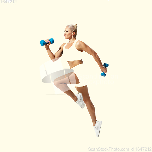 Image of Young caucasian sportswoman isolated on studio background, modern artwork. Healthy lifestyle, movement, action, motion, advertising and sports concept. Abstract design.
