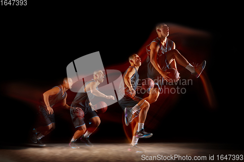 Image of Young east asian basketball player in action and jump in mixed strobe light over dark studio background. Concept of sport, movement, energy and dynamic, healthy lifestyle.