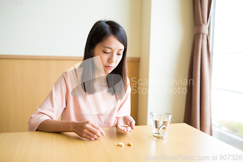 Image of Woman take medicine at home