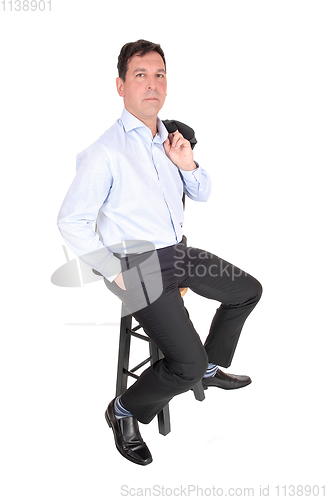 Image of A business man sitting with his jacked over shoulder