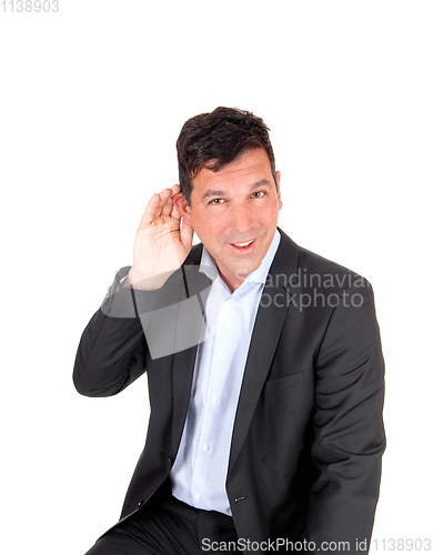 Image of Man sitting with hand on ear can not hear