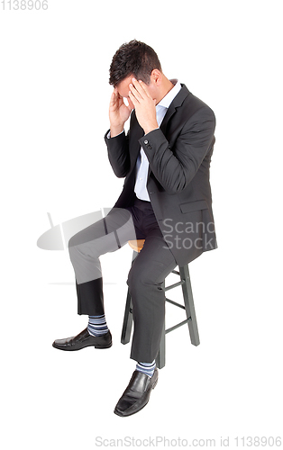 Image of Suffering man sitting and holding hands over face