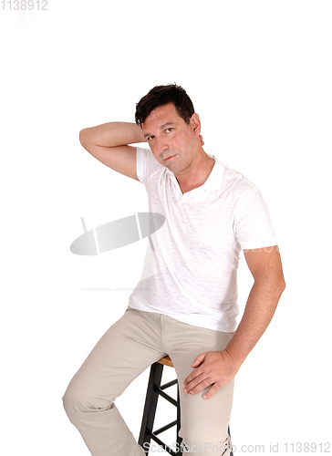 Image of Serious looking man sitting with hand on neck