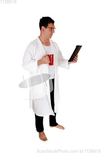 Image of Tall man standing in bathrobe and coffee mug