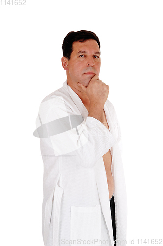 Image of Man standing in white bathrobe, looking to camera