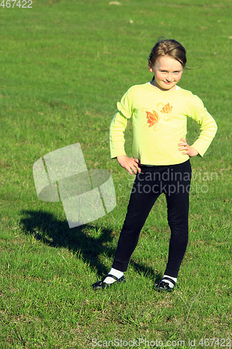 Image of little girl standing on the green grass