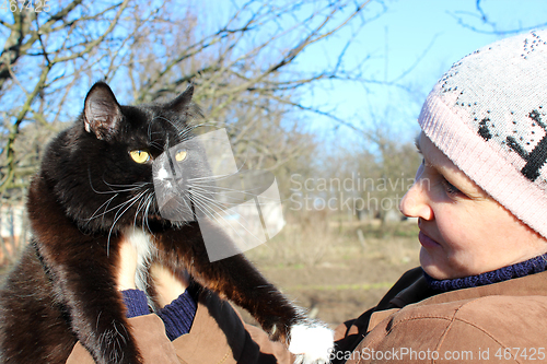 Image of woman looking at black cat