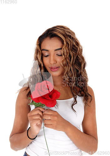Image of Lovely woman smelling her red rose