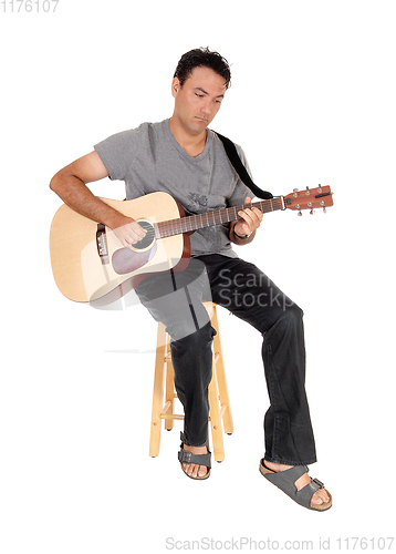 Image of Young casual man playing the guitar