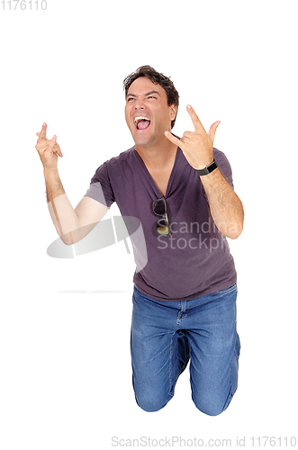 Image of Screaming young man kneeling on floor