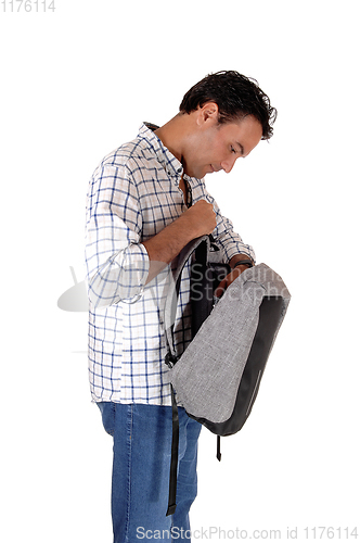 Image of Young tall man looking into his backpack