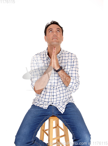 Image of Young man praying with his hands folded