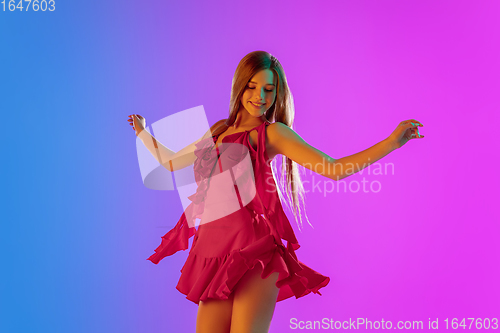 Image of Half-length portrait of happy seductive girl in romantic outfit dancing on bright gradient purple-blue background in neon light