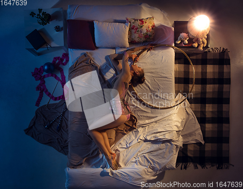 Image of Top view of young professional rhythmic gymnast sleeping at her bedroom in sportwear with ribbon.