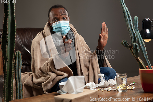 Image of Man wrapped in a plaid wearing face mask trying to protect from somebody\'s sick