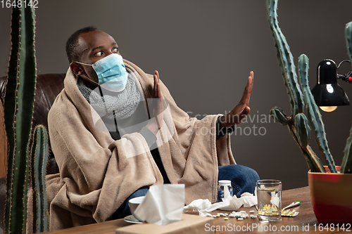 Image of Man wrapped in a plaid wearing face mask trying to protect from somebody\'s sick