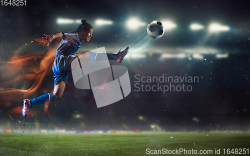 Image of Young man football or soccer player kicking ball in jump at stadium - motion, action, activity concept. Flyer for ad, design.