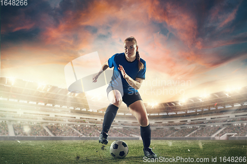 Image of Female football or soccer player at stadium - motion, action, activity concept. Flyer for ad, design.