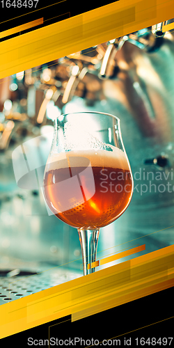 Image of Glass with foaming lager on bar rack. Vertical banner, flyer for ad.