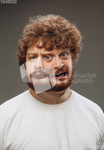 Image of Young man with dual emotions combination on face isolated on dark background, emotional and expressive