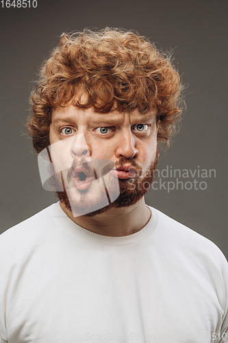 Image of Young man with dual emotions combination on face isolated on dark background, emotional and expressive