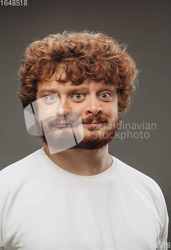 Image of Young man with dual emotions combination on face isolated on dark background, emotional and expressive