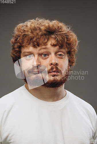 Image of Young man with dual emotions combination on face isolated on dark background, emotional and expressive