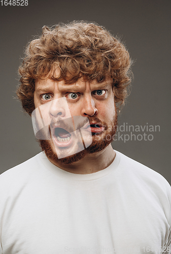 Image of Young man with dual emotions combination on face isolated on dark background, emotional and expressive