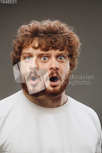 Image of Young man with dual emotions combination on face isolated on dark background, emotional and expressive