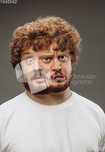 Image of Young man with dual emotions combination on face isolated on dark background, emotional and expressive