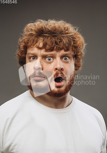 Image of Young man with dual emotions combination on face isolated on dark background, emotional and expressive