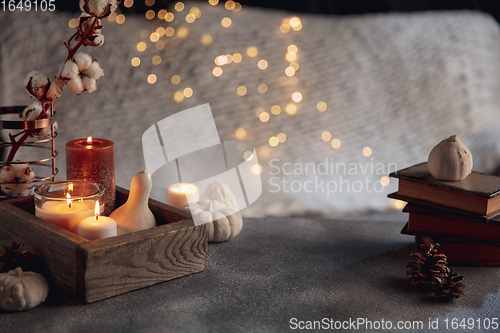 Image of Burning candles in the wooden box isolated on grey and white background with garland lights. Greeting card design.