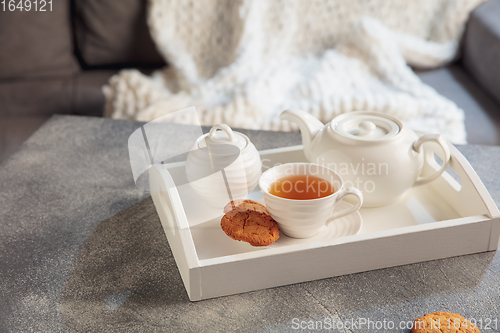 Image of White wooden tray with tea set on grey table. The concept of home atmosphere and comfort.