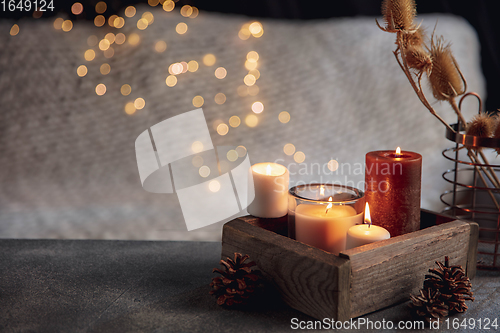 Image of Burning candles in the wooden box isolated on grey and white background with garland lights. Greeting card design.