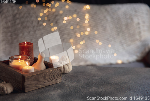 Image of Burning candles in the wooden box isolated on grey and white background with garland lights. Greeting card design.