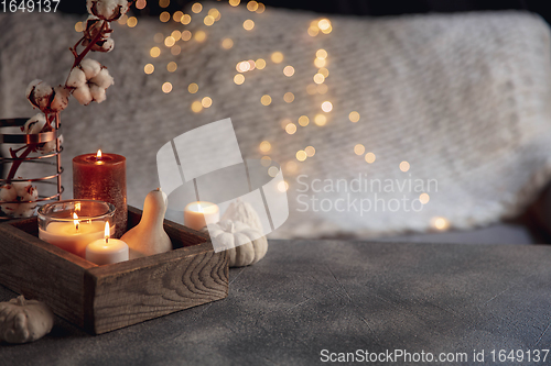 Image of Burning candles in the wooden box isolated on grey and white background with garland lights. Greeting card design.