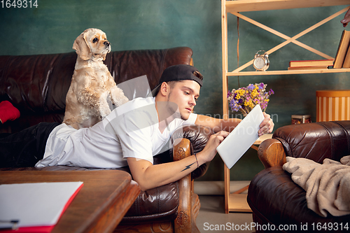 Image of Young Caucasian man and his pet American Cocker Spaniel cream colour have a rest at home.