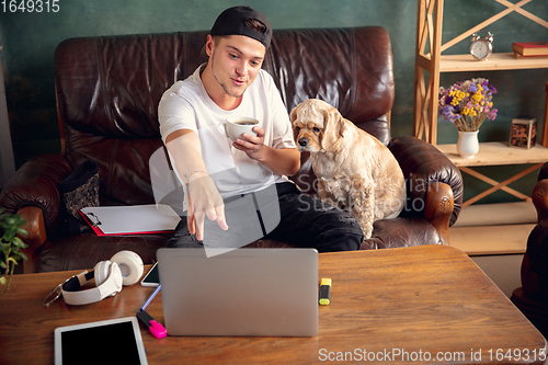 Image of Two best friends young man and American Cocker Spaniel cream colour drink tea at home.