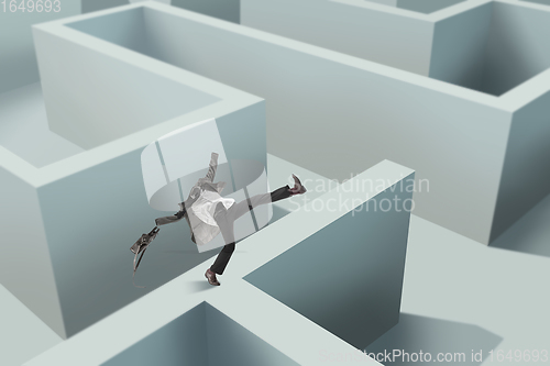 Image of Contemporary art collage. Young man without head wandering in a maze. Creativity, brain concept .