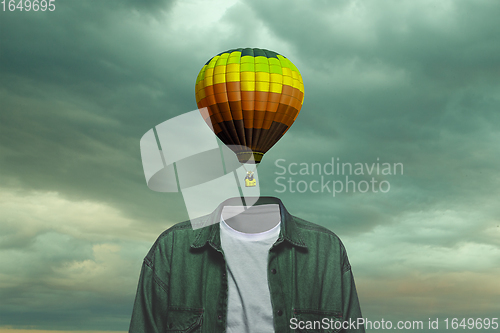 Image of Contemporary art collage. Male body of model with bright aerostat instead head isolated on blue grey background. Creativity, brain concept .