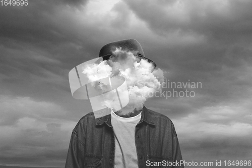 Image of Contemporary art collage. Black and white, Male body of model with head full of smoke about sky and clouds.
