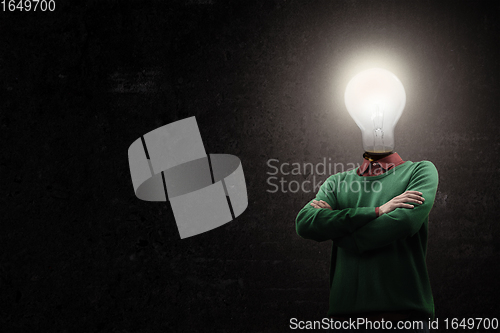 Image of Contemporary collage. Male body with electric bulb instead head isolated on black background. Creativity, brain concept .