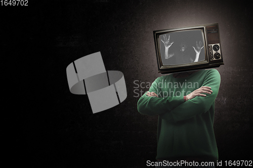 Image of Contemporary art collage. Male body with TV set instead head isolated on black background. Creativity, brain concept .
