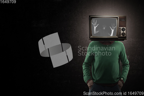 Image of Contemporary art collage. Male body with TV set instead head isolated on black background. Creativity, brain concept .