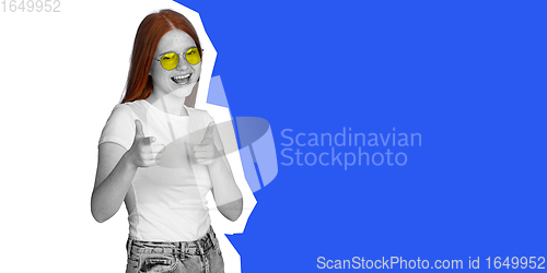 Image of Happy young beautiful girl posing isolated on blue and white background. Collage in magazine style. Flyer for ad.